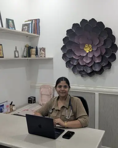 Dr. Richa Chandra at her desk at Ekam, a crafted dahlia on the wall behind her.