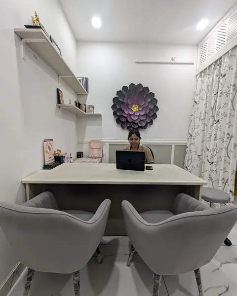 Dr. Richa Chandra at her desk across the consulting room at Ekam, two chairs in front of it.